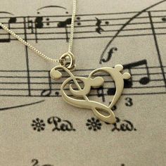 a musical note and treble pendant on top of sheet music