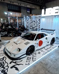 a white race car on display at an auto show