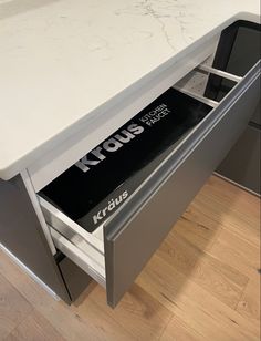 a white counter top sitting next to a metal drawer with klous stickers on it