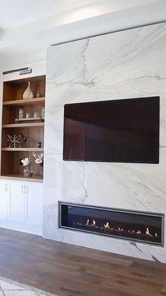 a living room with a fireplace and tv mounted on the wall above it's mantle