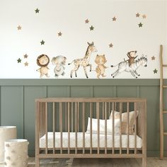 a baby's room with animals and stars on the wall, including a crib