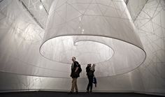 two people standing in front of a large white structure