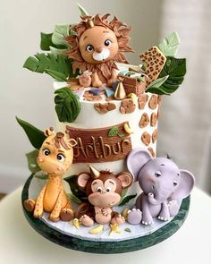 a three tiered cake decorated with animals and plants