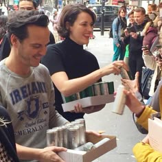 two people handing out cans to each other