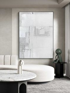 a living room filled with furniture and a large white painting on the wall above it