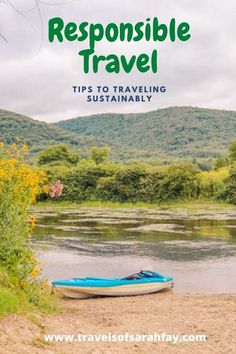 a boat sitting on top of a river next to a lush green forest covered hillside