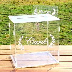 a clear box with the words candis on it sitting on a wooden table outside