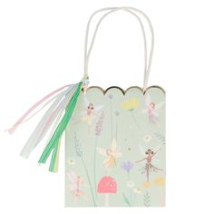 a small bag with fairy designs on it and tassels hanging from the handle