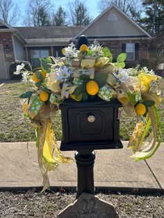 a mailbox decorated with flowers and lemons in front of a residential neighborhood house