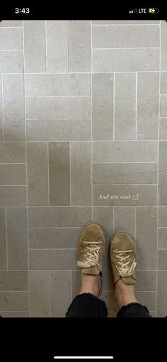 a person standing in front of a tiled wall with their feet on the toilet seat