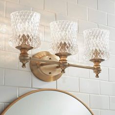 a bathroom light with three lights on the wall and a mirror in front of it