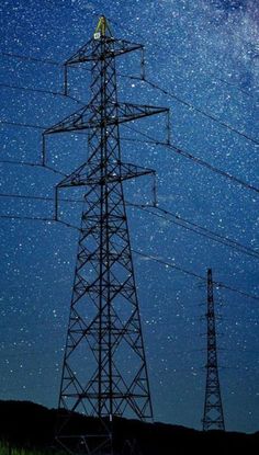 the night sky is filled with stars above power lines and high voltage towers that are connected to each other