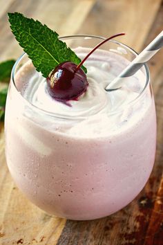 a glass filled with ice cream and topped with a cherries garnish on top