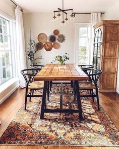 a dining room table with four chairs and a rug