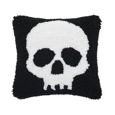 a black and white pillow with a skull on the front, it is made out of yarn