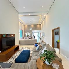 a living room filled with furniture and a flat screen tv on top of a wooden table