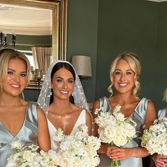 four bridesmaids in silver dresses holding bouquets