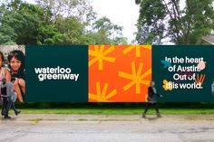 two people walking past a large advertisement on the side of a building