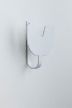 a white wall mounted toilet paper dispenser in the shape of a bird