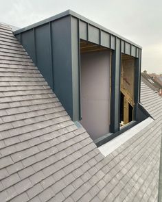 an open door is on the roof of a house that's being built with metal shingles