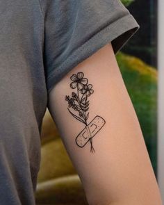 a person with a tattoo on their arm holding a knife and flower in the other hand