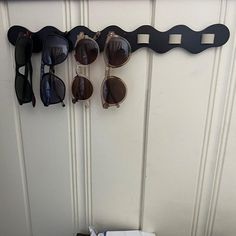 there are sunglasses hanging on the wall next to a towel rack with glasses in it