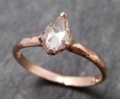 a rose cut diamond ring on top of a rock