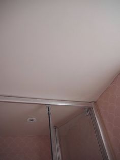 a bathroom with pink walls and white ceiling