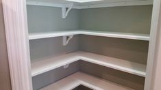 an empty white pantry with shelves in the corner