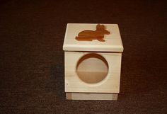 a wooden toy with a rabbit on it's side and the door open to reveal a hole in the floor