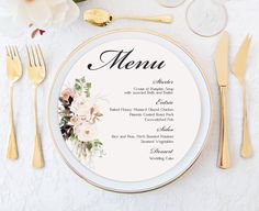 a white plate topped with a menu next to gold utensils