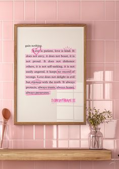 a pink tiled wall with a framed quote on it