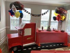 a birthday party setup with cars and balloons