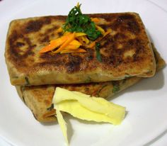 two quesadillas on a white plate with butter