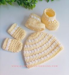 a crocheted hat, booties and mittens are sitting on a table