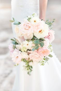 a bridal holding a bouquet of pink and white flowers