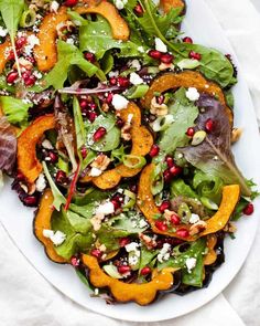 a white plate topped with salad and orange slices