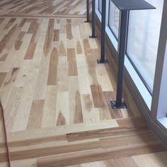 an empty room with wooden flooring and metal railings on the outside wall, looking out onto the street