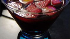 a close up of a drink in a glass with ice and fruit on the rim