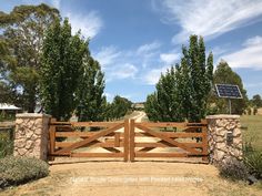 a wooden gate in the middle of a dirt road