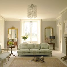 a living room filled with furniture and a dog laying on the floor