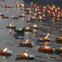 small bowls filled with food floating on top of a lake covered in fire flames and water