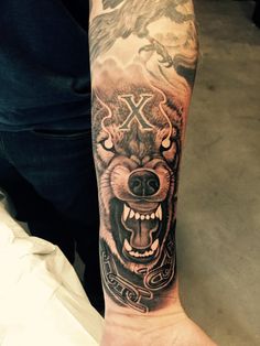 a man with a wolf tattoo on his arm