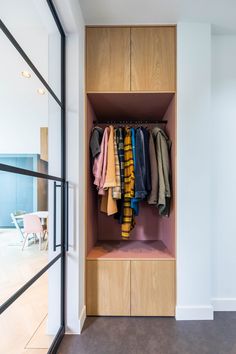 an open closet with clothes hanging on it