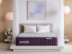 a purple mattress sitting on top of a white platform in a room with striped walls