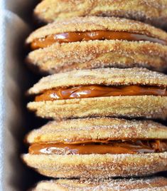 there are many donuts with chocolate icing in the box and on top of each other