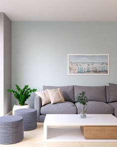 a living room filled with furniture and a painting on the wall above it's coffee table