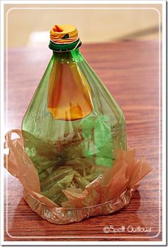 a green glass bottle sitting on top of a wooden table next to a paper bag