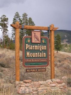 a wooden sign sitting on the side of a road