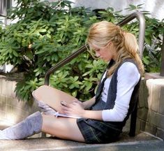 a young woman sitting on the steps writing